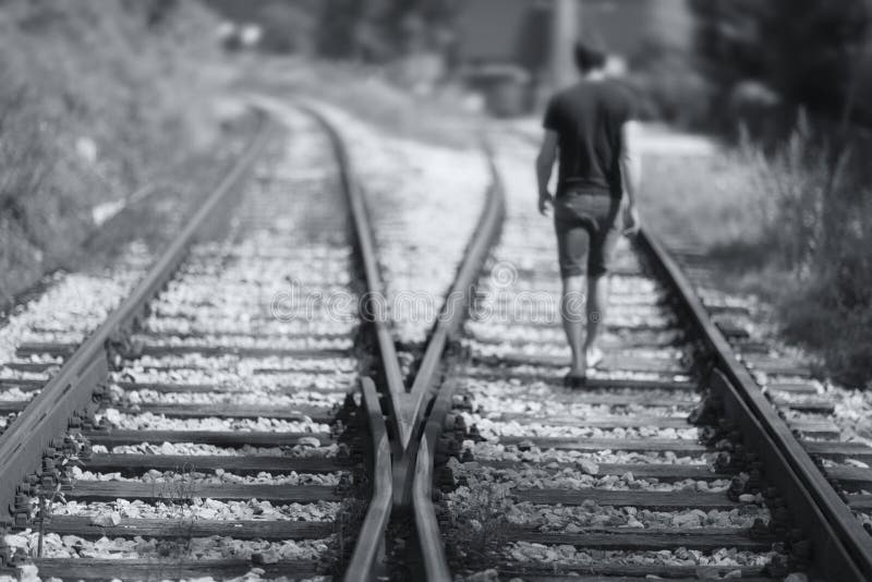 A Men Walking Down the Railway Tracks Stock Photo Image of leave
