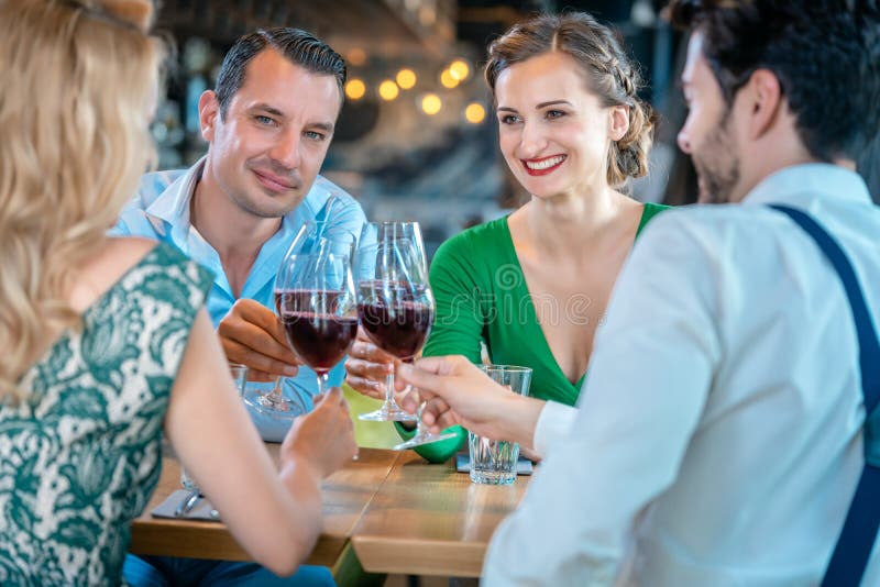 Men and women toasting with red wine in a restaurant royalty free stock images Men and women toasting with red wine in a restaurant royalty free stock images