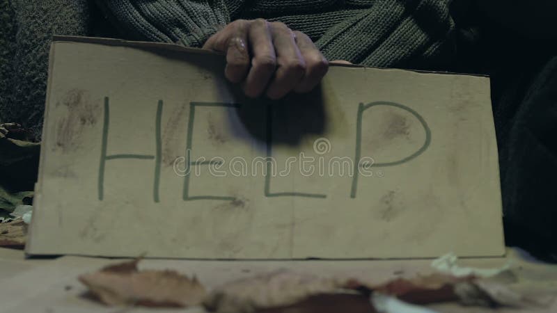 Mendiant tenant le signe d'aide, le problème de la pauvreté et le phénomène des sans-abri sur des rues de ville