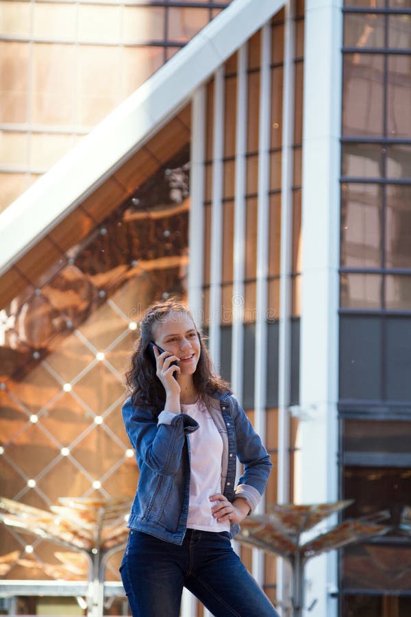 Menina adolescente que tem uma conversa do telefone celular em uma grande metrópole fotos de stock Menina adolescente que tem uma conversa do telefone celular em uma grande metrópole fotos de stock