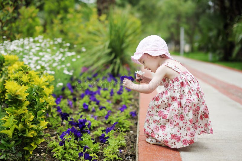 Adorable toddler girl holding two colorful flowers. Adorable toddler girl holding two colorful flowers