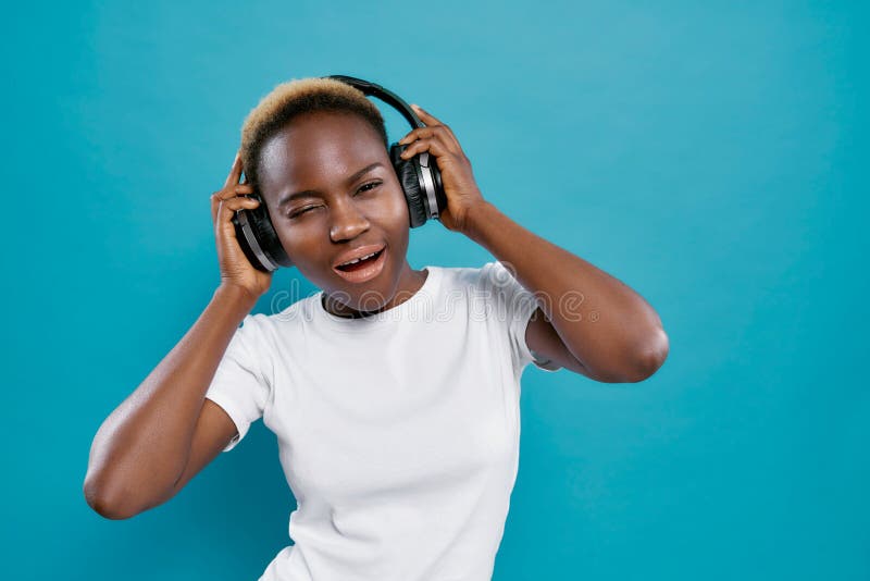 Menina africana fresca na música de escuta da camisa branca no estúdio imagem de stock royalty free Menina africana fresca na música de escuta da camisa branca no estúdio imagem de stock royalty free