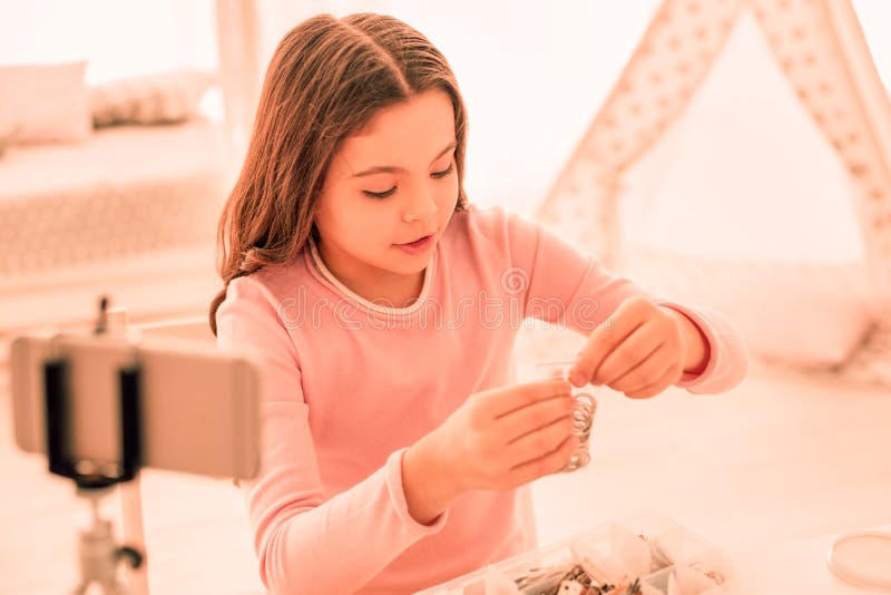 Menina agradável feliz que olha seus anéis imagem de stock Menina agradável feliz que olha seus anéis imagem de stock