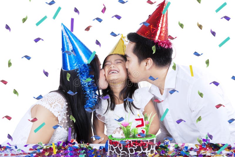 A menina alegre comemora o aniversário com pais fotografia de stock royalty free A menina alegre comemora o aniversário com pais fotografia de stock royalty free