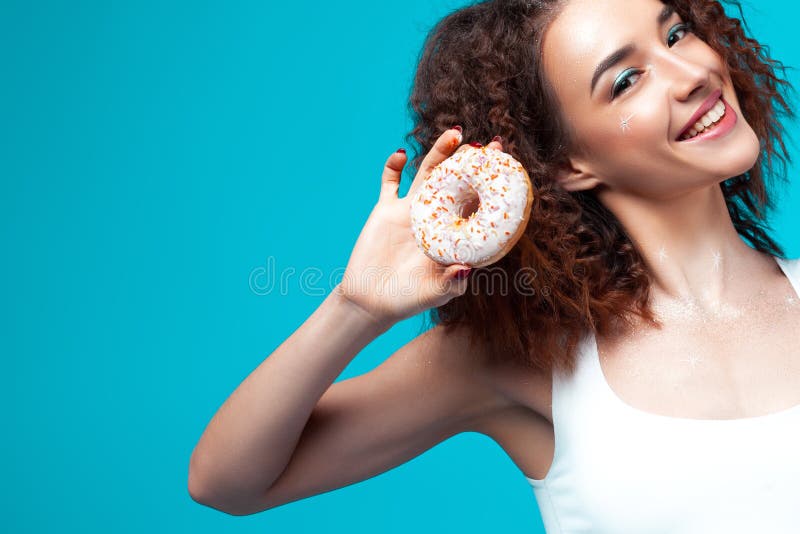 Menina alegre nova bonita com filhós à disposição imagem de stock Menina alegre nova bonita com filhós à disposição imagem de stock