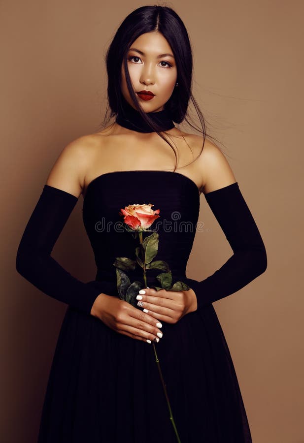 Menina asiática bonita do olhar com o cabelo preto que veste o vestido elegante imagens de stock royalty free Menina asiática bonita do olhar com o cabelo preto que veste o vestido elegante imagens de stock royalty free