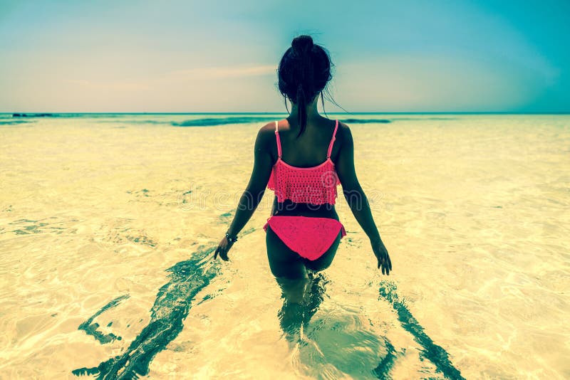 A menina asiática bonita nova no biquini aprecia férias de verão na praia tropical do paraíso Férias de verão e conceito do estil foto de stock A menina asiática bonita nova no biquini aprecia férias de verão na praia tropical do paraíso Férias de verão e conceito do estil foto de stock