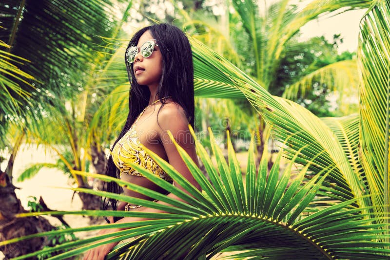 A menina asiática bonita nova no biquini aprecia férias de verão na praia tropical Férias de verão e conceito do estilo de vida imagens de stock royalty free A menina asiática bonita nova no biquini aprecia férias de verão na praia tropical Férias de verão e conceito do estilo de vida imagens de stock royalty free
