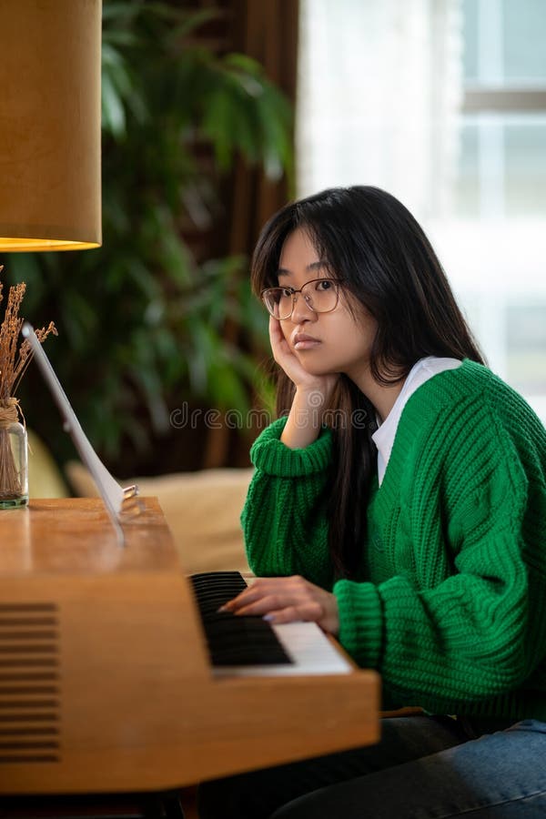 Menina asiática de cabelos longos sentada com um olhar infeliz imagem de stock