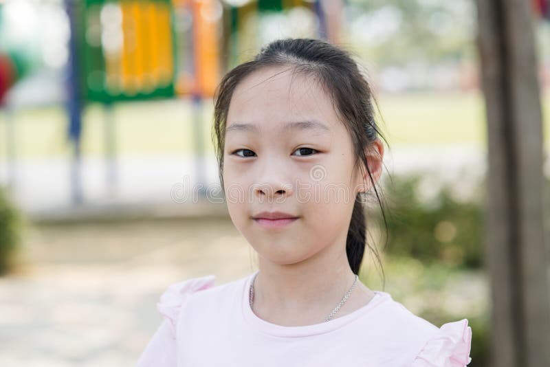 Menina asiática feliz no campo de jogos exterior imagens de stock Menina asiática feliz no campo de jogos exterior imagens de stock