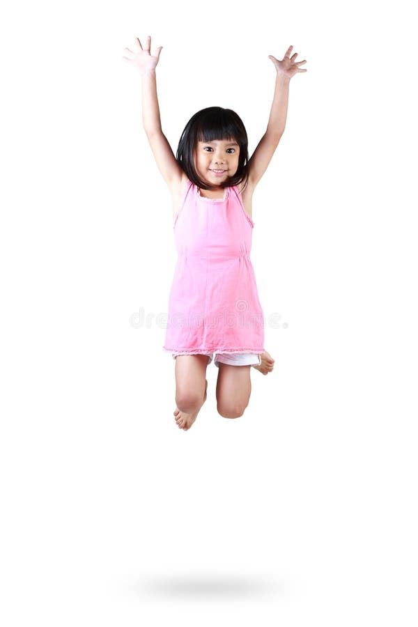 Menina asiática pequena adorável e feliz que salta no ar imagem de stock Menina asiática pequena adorável e feliz que salta no ar imagem de stock