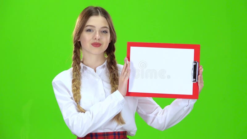 A menina aumenta uma tabuleta vermelha com papel Tela verde