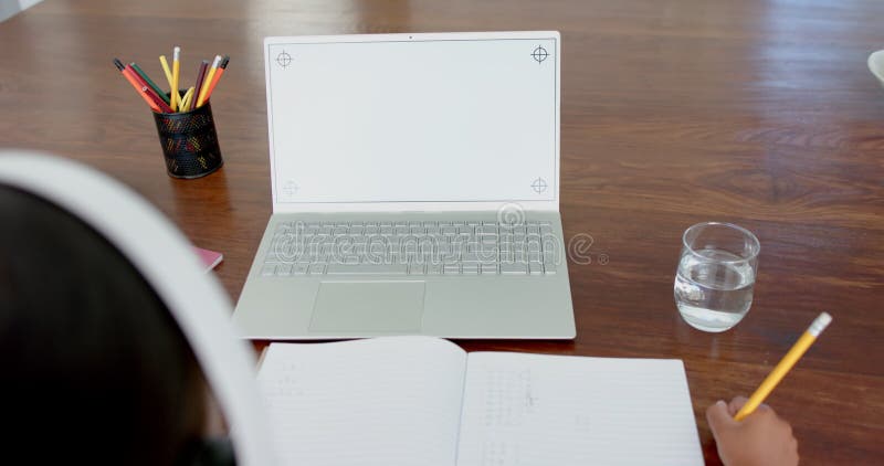 Menina biracial tendo aula de ensino fundamental em laptop com espaço de cópia em câmera lenta na tela