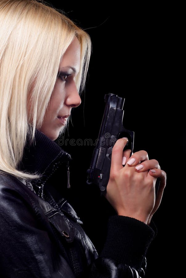 Linda rapariga com arma isolada sobre fundo preto imagens de stock royalty free