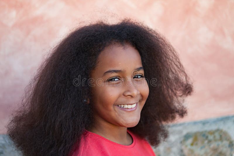Menina bonita com cabelo afro longo no jardim imagens de stock royalty free Menina bonita com cabelo afro longo no jardim imagens de stock royalty free