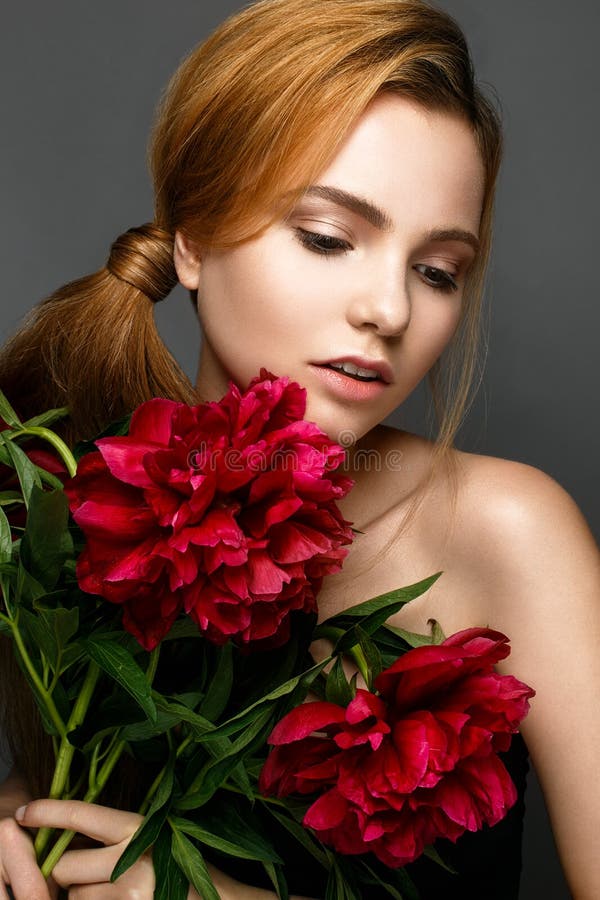 Menina bonita com um ramalhete das peônias Modelo com uma composição delicada Face da beleza fotos de stock Menina bonita com um ramalhete das peônias Modelo com uma composição delicada Face da beleza fotos de stock