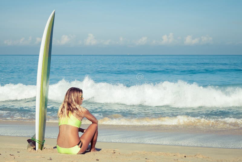 Beautiful Surfer Girl sitting on the Beach at the day time. Beautiful Surfer Girl sitting on the Beach at the day time