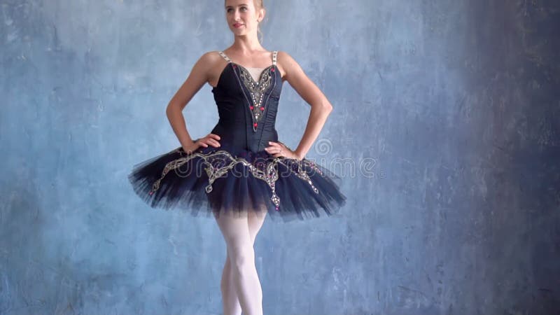 A menina bonita em um tutu levanta para a câmera na escola do bailado Bailado do russo Escola do bailado em Rússia E