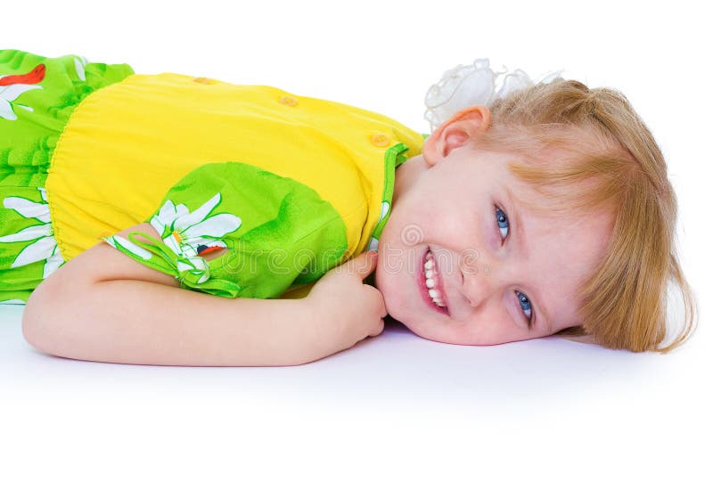 Menina bonita em um vestido verde com margaridas, mentiras na A.A. fotografia de stock royalty free Menina bonita em um vestido verde com margaridas, mentiras na A.A. fotografia de stock royalty free