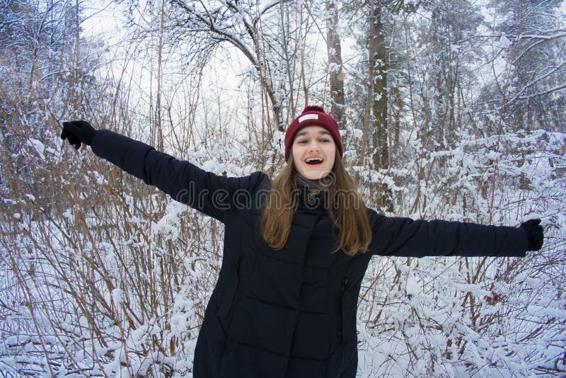 A menina bonita está feliz na floresta do inverno fotografia de stock A menina bonita está feliz na floresta do inverno fotografia de stock