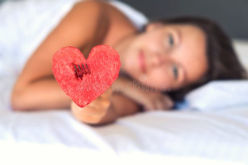 A menina bonita na cama dá o coração da melancia em uma forquilha fotos de stock A menina bonita na cama dá o coração da melancia em uma forquilha fotos de stock
