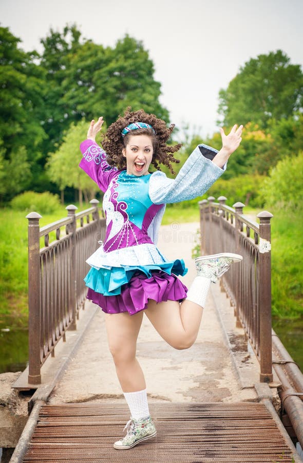 Menina bonita nova no vestido irlandês da dança que tem o divertimento exterior imagem de stock royalty free Menina bonita nova no vestido irlandês da dança que tem o divertimento exterior imagem de stock royalty free