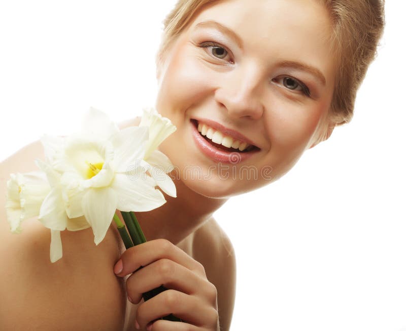 Menina bonita que sorri e com narciso da flor fotografia de stock