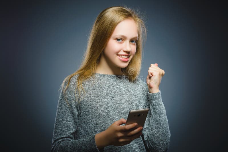 Menina bonito feliz com telefone celular Isolado no cinza fotografia de stock royalty free Menina bonito feliz com telefone celular Isolado no cinza fotografia de stock royalty free