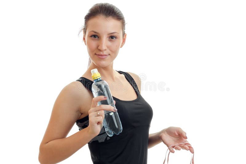 Young cute girl looks into the camera and holds water bottle close-up on white background. Young cute girl looks into the camera and holds water bottle close-up on white background