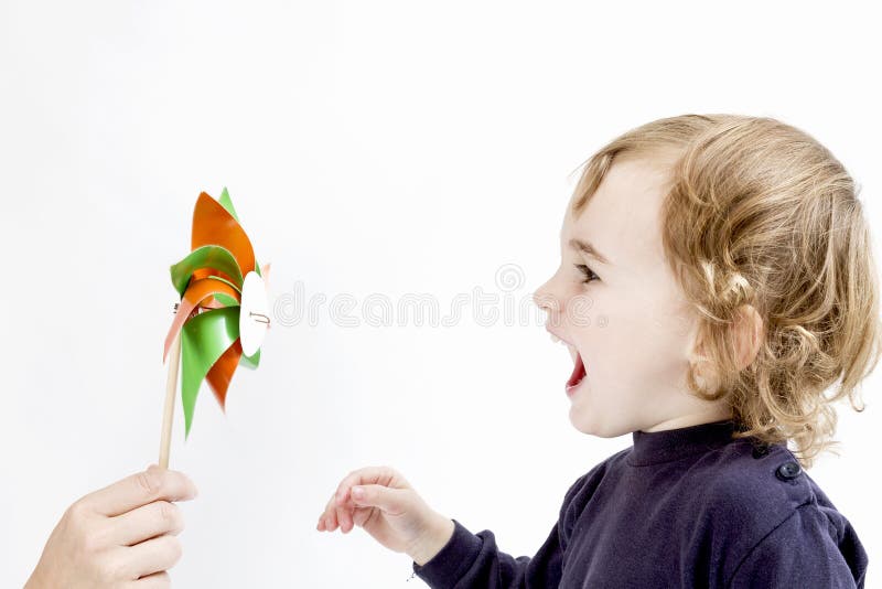Menina bonito que funde ao moinho de vento fotografia de stock Menina bonito que funde ao moinho de vento fotografia de stock