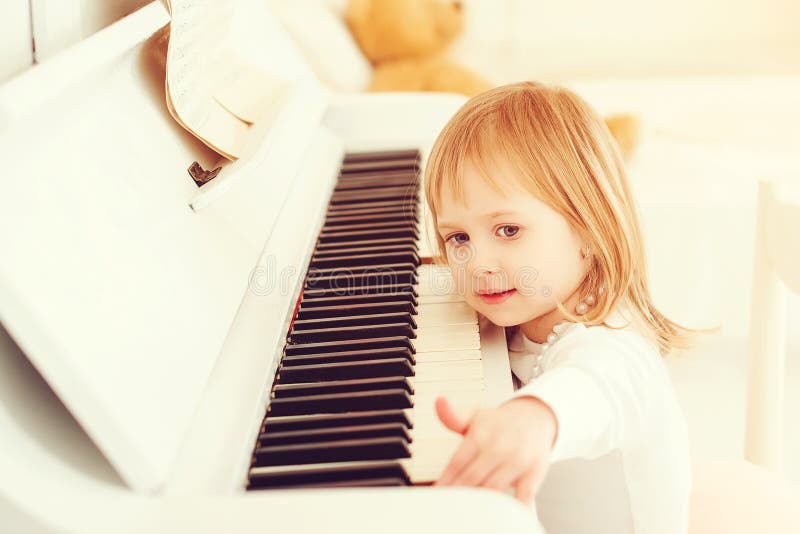 Menina bonito que joga o piano em uma escola de música Criança pré-escolar que aprende jogar o instrumento de música Educação, co imagens de stock Menina bonito que joga o piano em uma escola de música Criança pré-escolar que aprende jogar o instrumento de música Educação, co imagens de stock