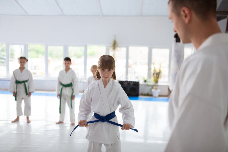 Menina bonito que tem a cara séria antes de praticar o aikido fotografia de stock Menina bonito que tem a cara séria antes de praticar o aikido fotografia de stock