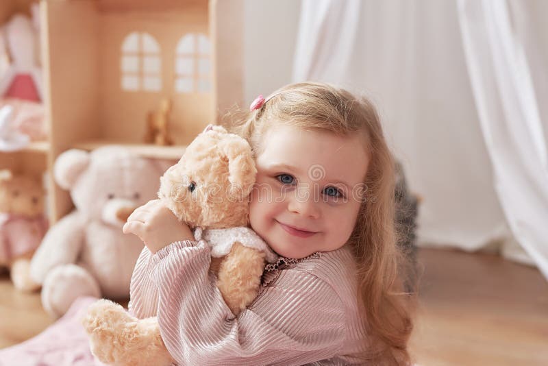 A menina está jogando na sala de jogos infantil berçário escandinavo  brinquedos de madeira e decoração