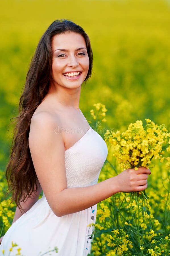 Menina com as flores no campo do verão imagens de stock Menina com as flores no campo do verão imagens de stock