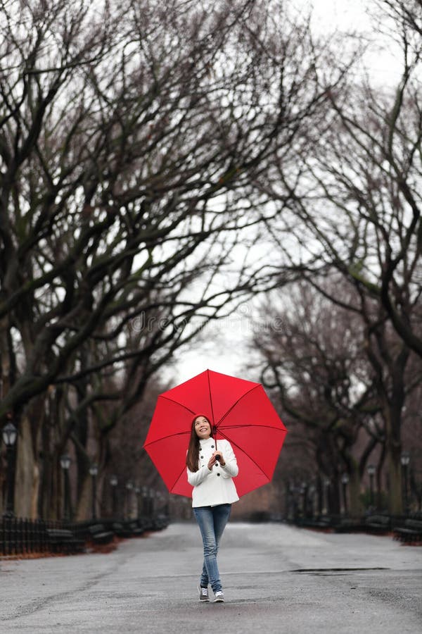 Menina com guarda-chuva vermelho que anda no parque na queda fotos de stock royalty free Menina com guarda-chuva vermelho que anda no parque na queda fotos de stock royalty free