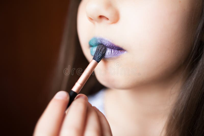 Menina com lipsteak azul em seus bordos imagens de stock royalty free Menina com lipsteak azul em seus bordos imagens de stock royalty free