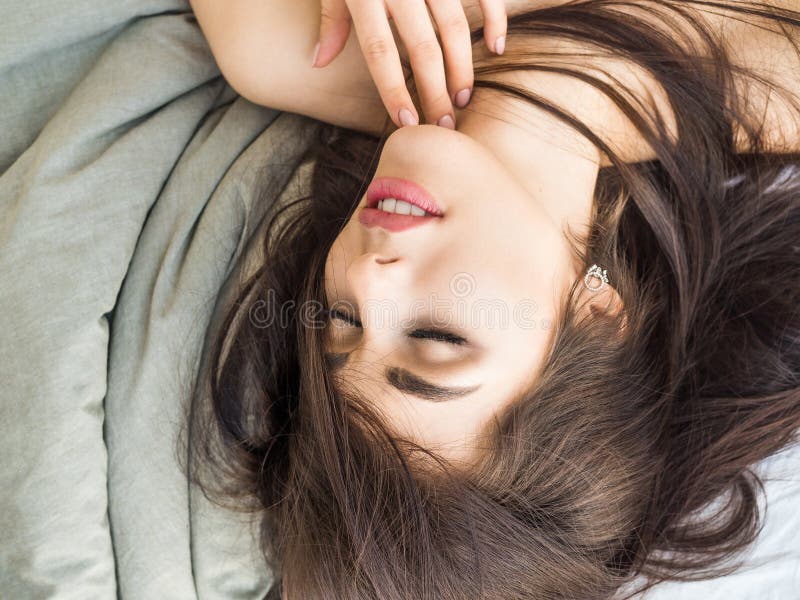 Menina com o cabelo bonito que encontra-se na cama Conceito do cuidado de pele imagens de stock Menina com o cabelo bonito que encontra-se na cama Conceito do cuidado de pele imagens de stock
