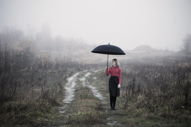Menina com o guarda-chuva no campo do outono fotografia de stock royalty free Menina com o guarda-chuva no campo do outono fotografia de stock royalty free