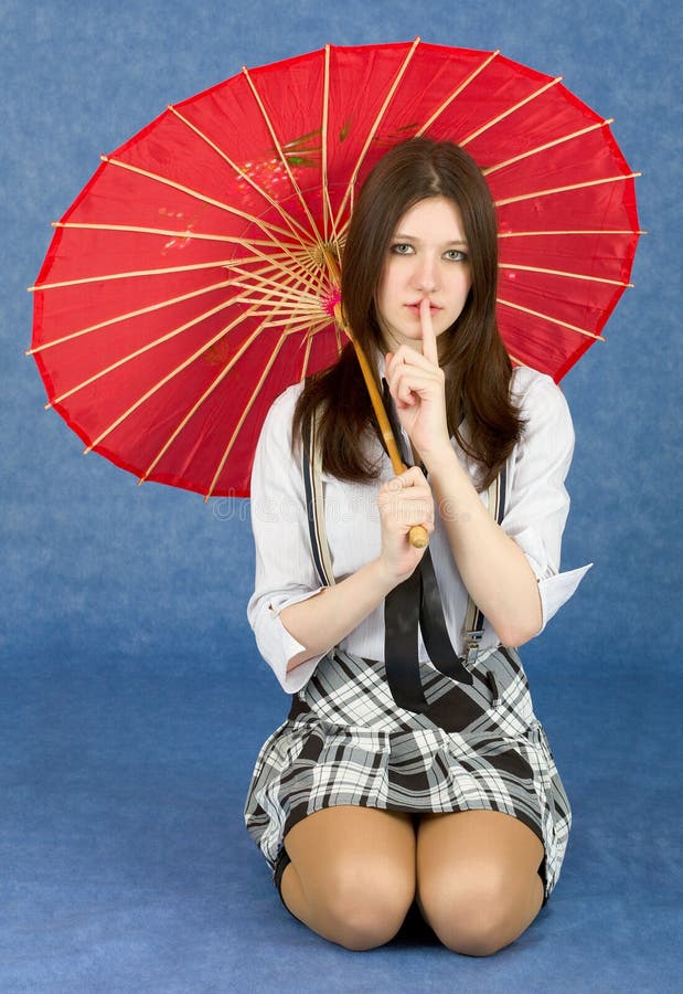 Menina com o guarda-chuva oriental vermelho no azul fotografia de stock Menina com o guarda-chuva oriental vermelho no azul fotografia de stock