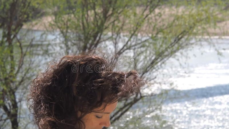 Menina com o portátil que trabalha no ar fresco Uma mulher está datilografando em um portátil pelo rio