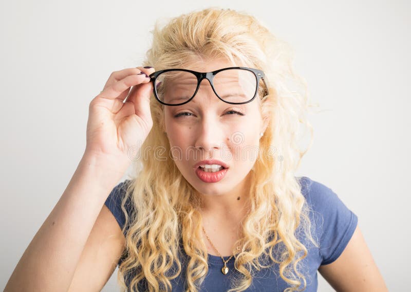 A menina com seus vidros levantados acima do ` t da lata vê imagem de stock A menina com seus vidros levantados acima do ` t da lata vê imagem de stock