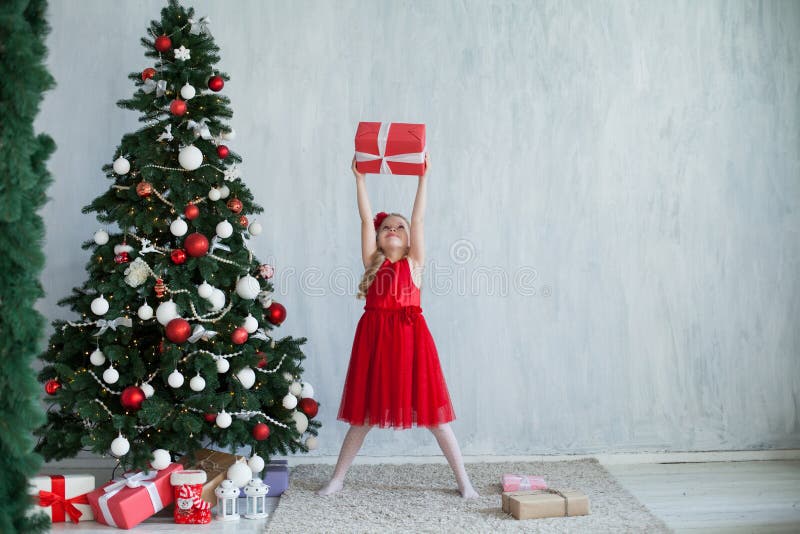 Menina com a árvore de Natal do ano novo dos presentes em presentes cinzentos de um fundo imagens de stock Menina com a árvore de Natal do ano novo dos presentes em presentes cinzentos de um fundo imagens de stock
