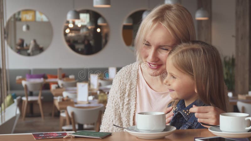 Uma menina partilha alguns segredos com a sua mãe foto de stock