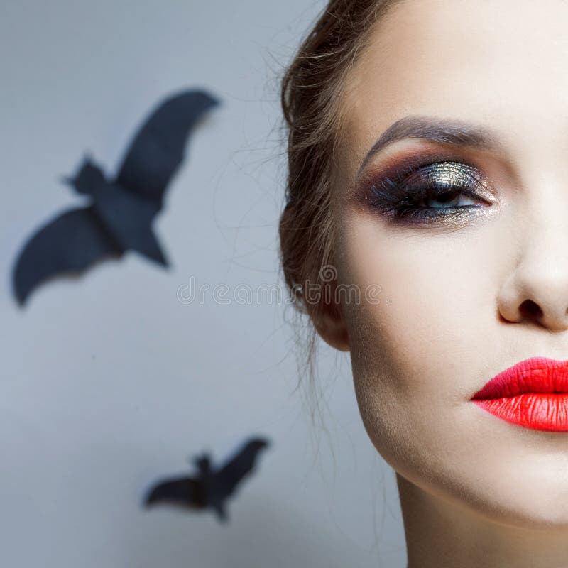 Menina da composição de Dia das Bruxas, a brilhante e a à moda com composição vermelha dos bordos e dos olhos de Smokey fotografia de stock royalty free Menina da composição de Dia das Bruxas, a brilhante e a à moda com composição vermelha dos bordos e dos olhos de Smokey fotografia de stock royalty free