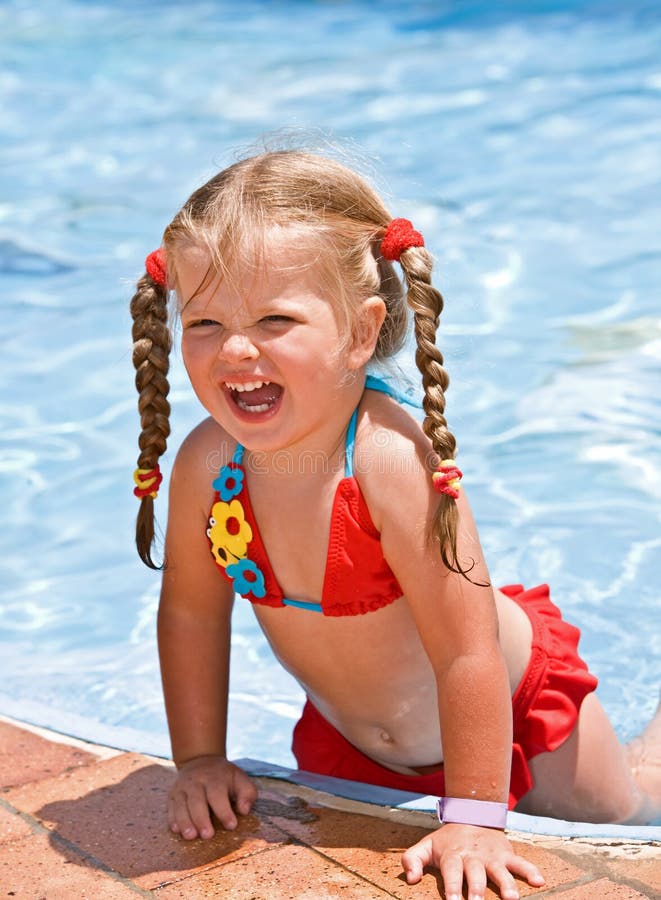 Menina da criança no biquini vermelho perto da piscina azul. imagens de stock Menina da criança no biquini vermelho perto da piscina azul. imagens de stock