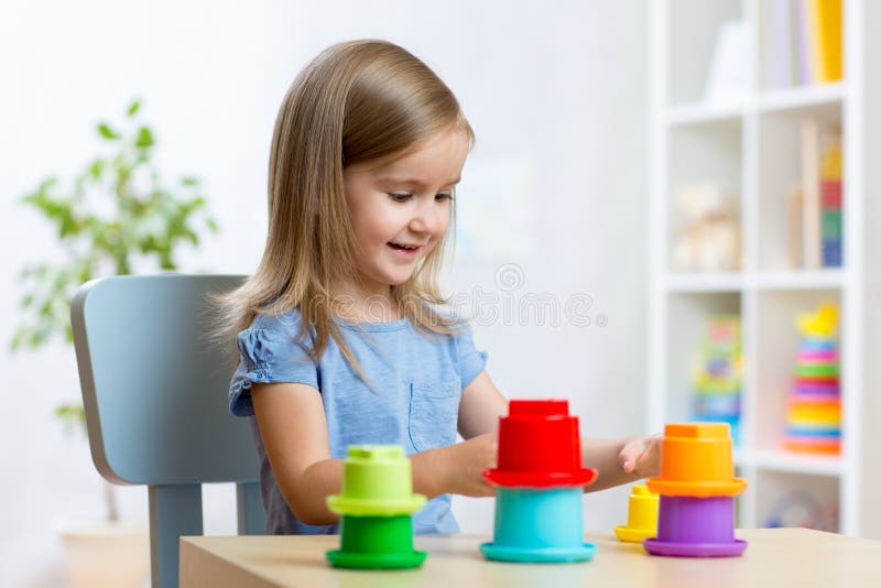 Menina pequena a brincar com brinquedos dentro de casa imagens de stock royalty free