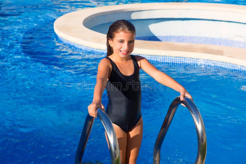 Menina das crianças no roupa de banho preto das escadas azuis da associação foto de stock Menina das crianças no roupa de banho preto das escadas azuis da associação foto de stock