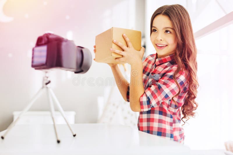 Menina de cabelo escuro bonita que olha muito engraçada após ter obtido sua caixa de presente fotos de stock Menina de cabelo escuro bonita que olha muito engraçada após ter obtido sua caixa de presente fotos de stock