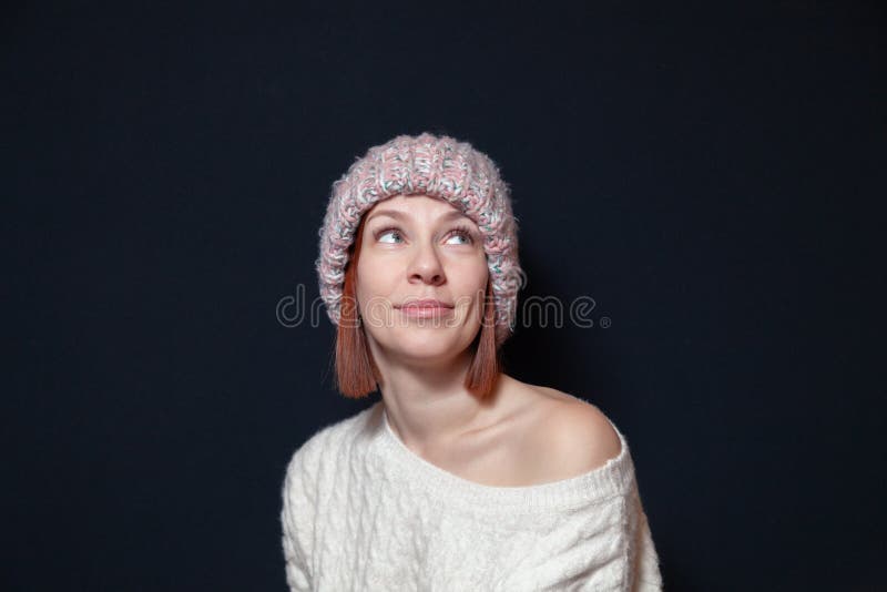 Menina de cabelo vermelha de sorriso nova com corte de cabelo do prumo no chapéu cor-de-rosa, camiseta bege feita malha em um fun fotos de stock Menina de cabelo vermelha de sorriso nova com corte de cabelo do prumo no chapéu cor-de-rosa, camiseta bege feita malha em um fun fotos de stock