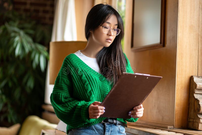 Músico. menina de cabelos longos examinando uma folha de música e parecendo concentrada